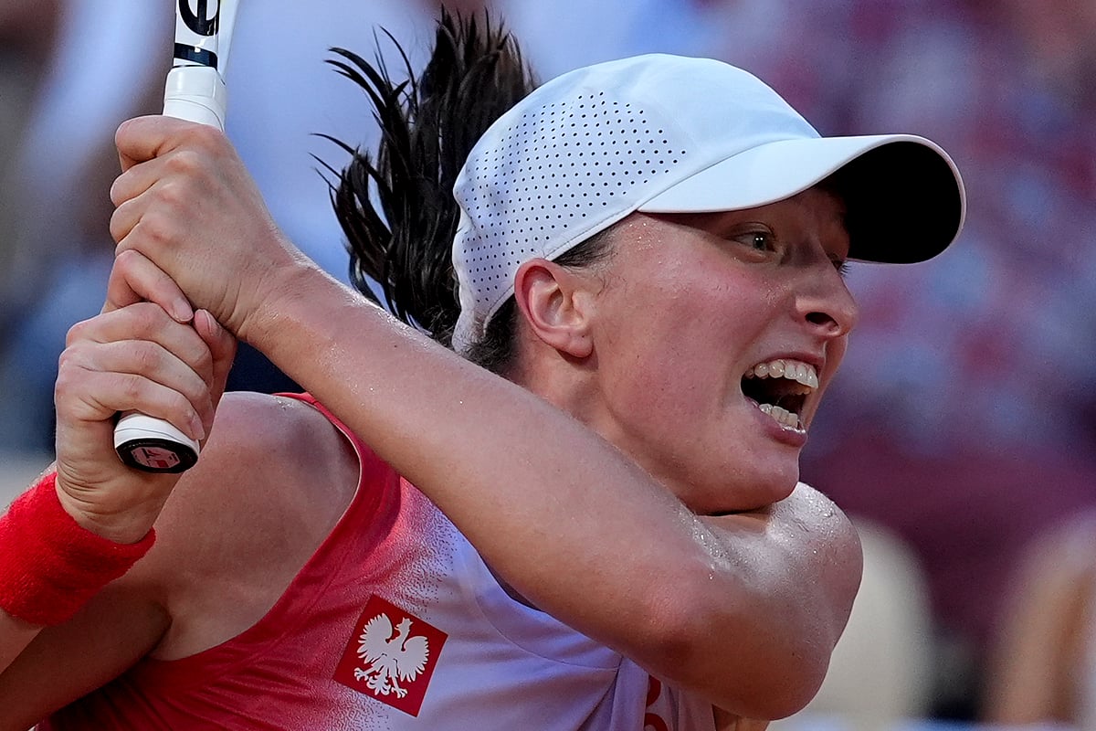 Iga Swiatek of Poland returns a shot to Wang Xiyu of China during their women's singles third round match at the Roland Garros stadium, at the 2024 Summer Olympics, Tuesday, July 30, 2024, in Paris, France.  - (AP Photo/Andy Wong)
